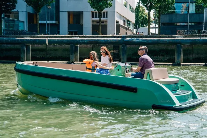 Een gezin vaart zelf in een groene elektrische Santos-sloep door de binnenhavens van Rotterdam