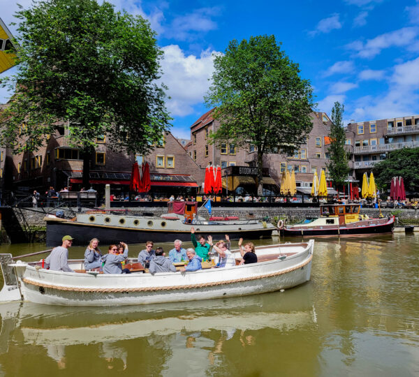 Gasten zwaaien vanaf de rondvaartboot in de Oude Haven