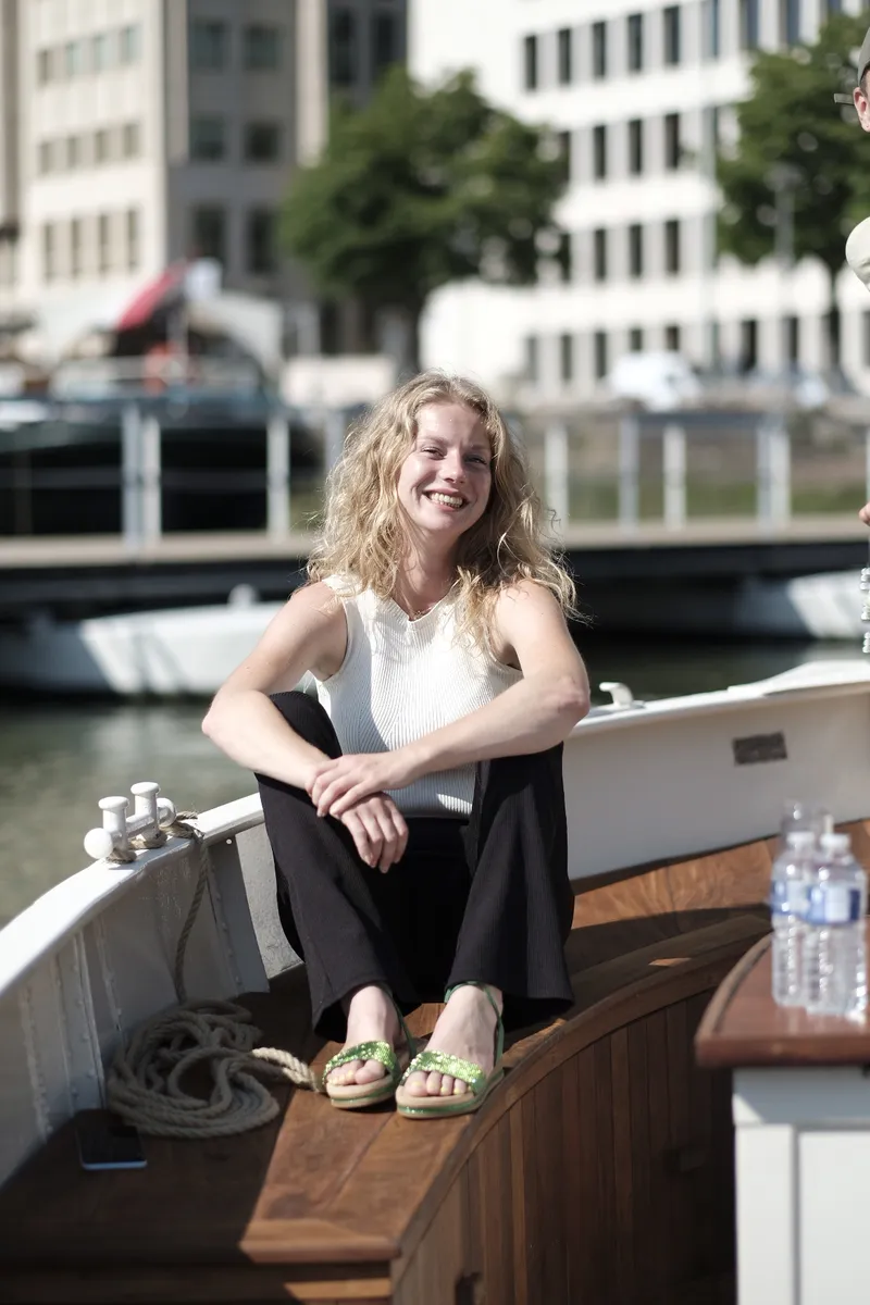 Een gast zit ontspannen aan boord van de rondvaartboot in Rotterdam
